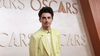 Timothée Chalamet vaalean keltaisessa puvussa ja saman värisessä paidassa.