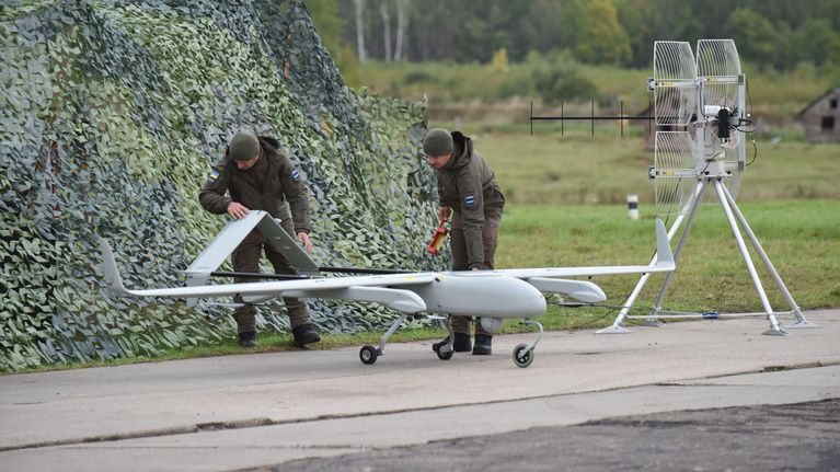 Sotilaat valmistelevat miehittämätöntä lentolaitetta lennolle kenttäolosuhteissa.