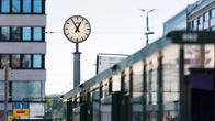 En klocka som visar fem före ett vid en spårvagnshållplats.