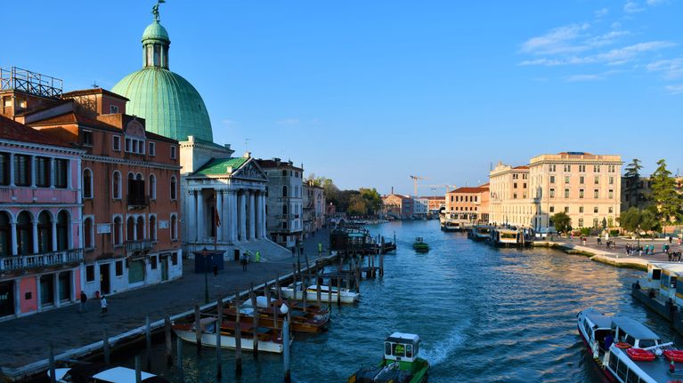 Vy från Venedig med en bred kanal med flera båtar.