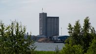 Bild av ett industriellt område med en stor byggnad vid vattnet.