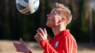 Rudi Vikström leker med bollen på en fotbollsplan.