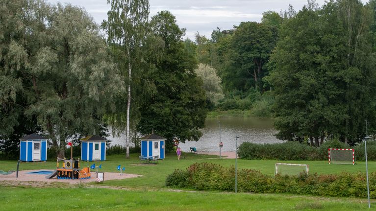 Strand med blåa badhytter.