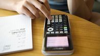 Nuori laskee matematiikan tehtäviä.