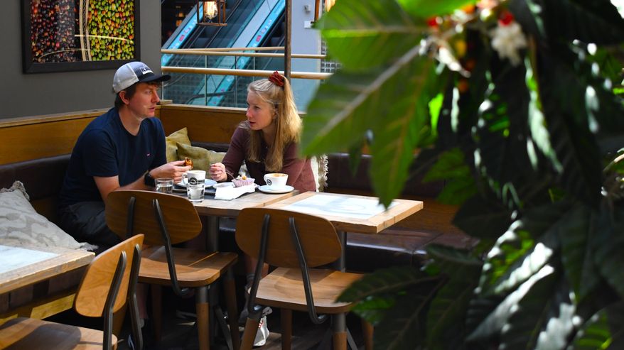 Minttu Hukka och Robert Sroka sitter på café.