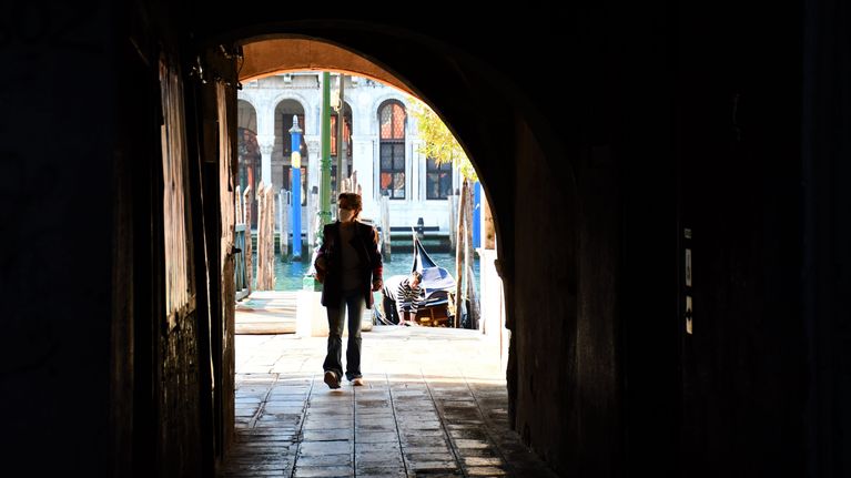 En person går in i en gång i Venedig.