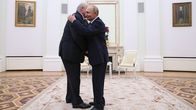 Putin ja  Lukašenka halaavat toisiaan valkoisessa salissa.