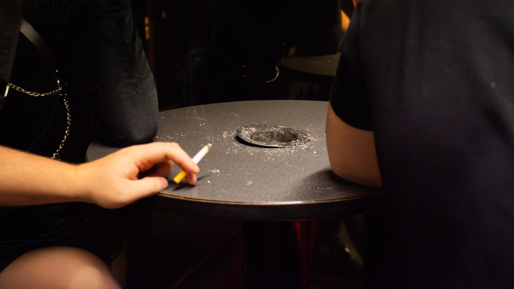 Kuvassa on Hyvinkään Hopealyhty-yökerhon tupakkakoppi, jossa asiakkaita tupakalla.