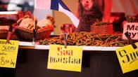 Torilla herneitä myynnissä, niiden edessä keltainen saa maistaa -kyltti.