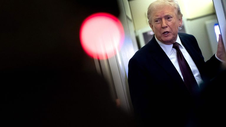 Donald Trump nojaa ovenpieleen virkalentokoneessaan.