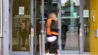 Turun yliopiston tiedekunnan ulko-ovi, jossa henkilö astuu sisään rakennukseen.