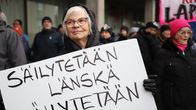 Maire Virtanen seisoo "Säilytetään Länskä, säilytetään henki" -kyltin kanssa osoittamassa mieltä Länsi-Pohjan sairaalan puolesta Kemissä 26.10.2025.