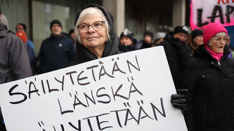 Maire Virtanen seisoo "Säilytetään Länskä, säilytetään henki" -kyltin kanssa osoittamassa mieltä Länsi-Pohjan sairaalan puolesta Kemissä 26.10.2025.