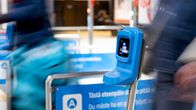 Metro station ticket machine. Blurred people walking in the background.