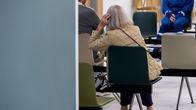 A woman sits in a hospital waiting area.