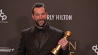 Näyttelijä Noah Wyle katsoo hymyillen kameraan kädessään juuri voittamansa Golden Globe -palkinto.