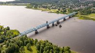 A bridge runs over a summery river valley.