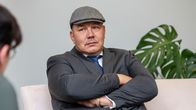 Juha Mäenpää istuu penkillä kädet puuskassa.