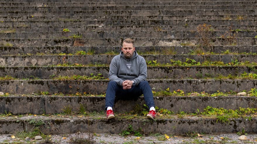 Leijonien päävalmentaja Antti Pennanen istuu kivisillä portailla Ahvenistonjärvellä Hämeenlinnassa.