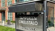Musta kyltti, jossa lukee valkoisella tekstillä Tampereen oikeustalo Kelloportinkatu 5 A. 