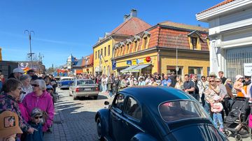 Autojen letka-ajo Raumalla, paljon ihmisiä katselemassa jalkakäytävillä.