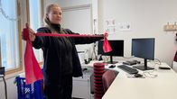 Fysioterapeutti Aliisa Katainen näyttää miten kuminauhaa käytetään.