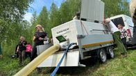 Peräkärryssä iso valkoinen sammio, josta johtavaa putkea pitkin lohenpoikaset pääsevät jokeen. Sammiossa teksti Elävää kalaa.