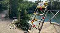 Diving tower taped off with red tape, and a warning sign on the steps.