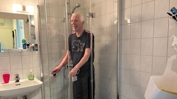 Timo Pulkkinen näyttää miten uusi suihkukaappi toimii. 