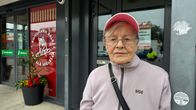 Nainen seisoo kaupan edustalla. Ilme on totinen.