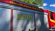 Paloauto sivusta kuvattuna. Ovessa on auton tunnus KP111.