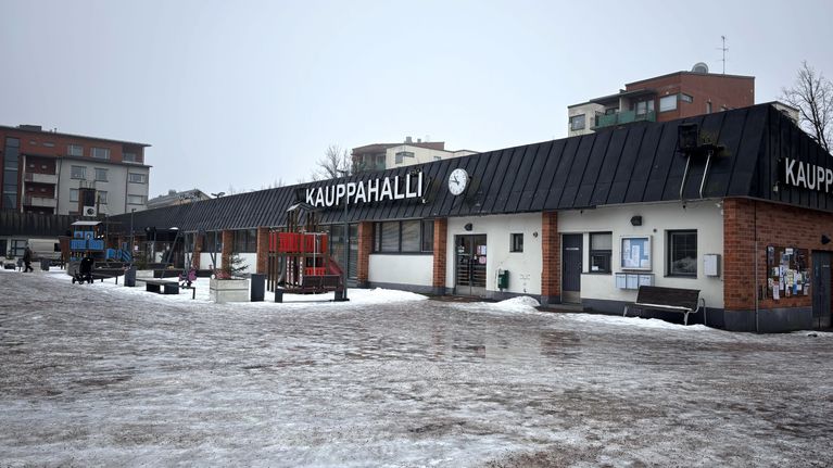 Lappenrannan kauppahalli on matala rakennus, jonka edustalla on lasten leikkipaikka.