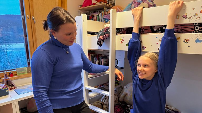 Elle-Maija Niittyvuopio-Jämsä riippuu kerrossängyssä ja katsoo äitiinsä Leenaan.