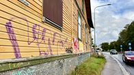 Vanha puutalo, jonka seinissä on erivärisiä graffiteja. Talo sijaitsee Pispalan valtatien varrella, missä kulkee autoja.