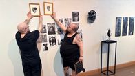 Joensuulainen Iro Immonen asettelee tauluja seinälle taidekeskus Ahjon näyttelyä varten.