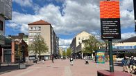 Kävelykatu, kerrostaloja taustalla. Ihmisiä.