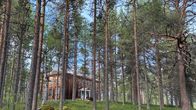 Kuvassa on Koppelon vanha koulu eli Ruottukan koulu. Edessä on puita. Koulurakennus on hirsirakenteinen.