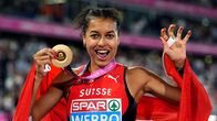 Yleisurheilija seisoo yleisön edessä pitäen mitalia ja Sveitsin lippua, paidassa teksti “SPAR WERRO BIRMINGHAM 2024”.