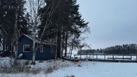 Kuvassa on sininen mökki saaressa.