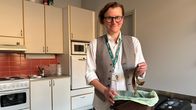 Henkilö seisoo keittiössä ja laittaa banaaninkuoria biojäteastiaan. Taustalla näkyy keittiövälineitä ja jäteastioita.