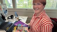 Mediatutkija Laura Antola pitelee väitöskirjansa versiota ja sarjakuvalehtiä käsissään työhuoneessaan Turun yliopistolla.