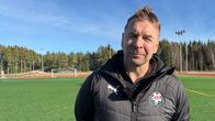 Jalkapallovalmentaja seisoo jalkapallokentäälä ja katsoo kameraa kohti.