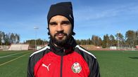 Jalkapalloilija Sergei Eremenko seisoo jalkapallokentällä, pukeutuneena FF Jaron punaiseen treenitakkiin. 