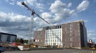 Iso tontti, jossa on paljon tyhjää tilaa sekä rakenteilla oleva korkea hotellirakennus ja nosturi.