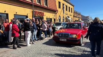 Autojen letka-ajo Raumalla, paljon ihmisiä katselemassa jalkakäytävillä.