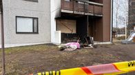 Kerrostalon pihaa ja palaneita tavaroita pihalla sekä eristysnauhaa. 