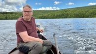Mies ajaa puuveneellä järvellä. Ilmari Tapiola Mantojärvellä. 