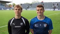 Två personer står på en fotbollsplan klädda i olika sportkläder.