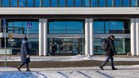 Eteläranta 10:n ulko-ovi kuvattu kadun toiselta puolelta, etualalla 2 ihmistä.
