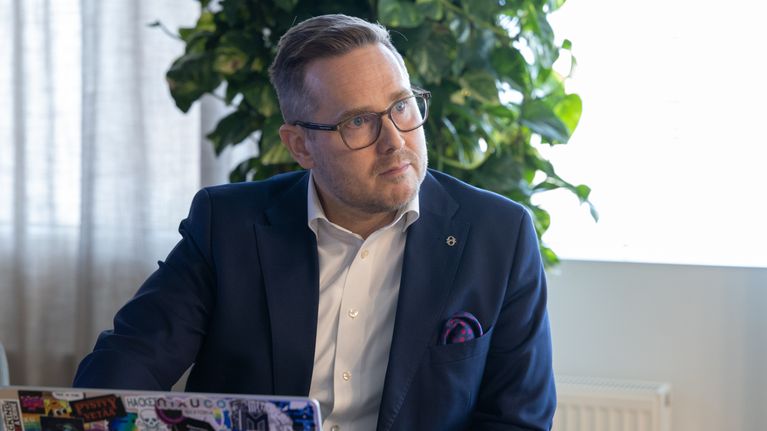 En man sitter framför en bärbar dator.